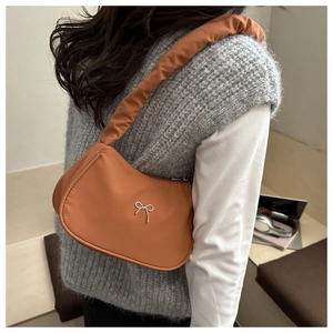 Close-up of brown butterfly bow shoulder bag with stylish ruched cloud-style strap