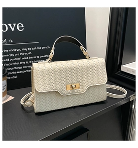 Détail d'un sac bandoulière crème tressé avec fermoir doré et texture en cuir lisse