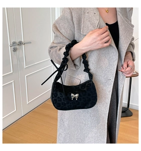 Detail of leopard print handbag with silver butterfly buckle and pleated handle