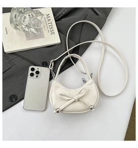 Vue détaillée du mini sac bandoulière croissant avec nœud et perles argentées
