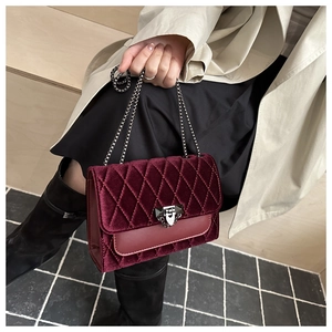 Detail view of burgundy quilted velvet chain bag showing elegant texture and metal strap