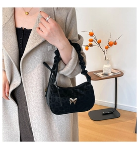 Close-up of black leopard print shoulder bag with gold butterfly buckle and pleated strap