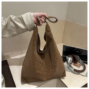 Detailed shot of large leopard print tote bag on minimalist desk with lifestyle props