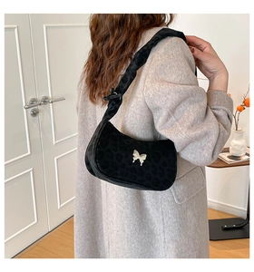 Detail of black leopard print faux fur shoulder bag with silver butterfly buckle