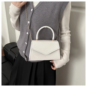 Side view of white envelope crossbody bag with gold chain strap and pleated top handle