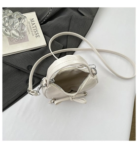 Vue détaillée de l'intérieur du sac crème avec doublure chevron et motif nœud