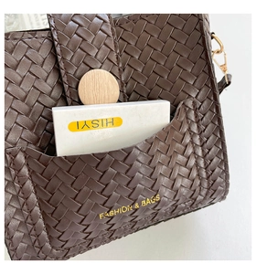 Gros plan d'un sac seau en cuir PU tressé marron avec boucle bois et logo doré