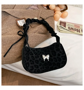 Detail of leopard print faux fur handbag with silver butterfly buckle and pleated strap