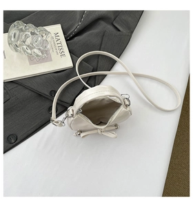 Détail du sac à nœud crème montrant la doublure intérieure et l'espace zippé