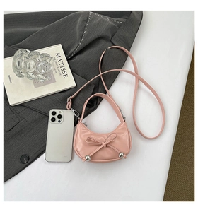 Vue détaillée du sac rose mat en forme de boulette avec nœud et perles argentées