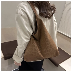 Detail of dark brown tote bag showing leopard print texture and large capacity on shoulder