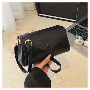 Detail of black leather texture on a chic handbag with gold hardware and wide strap