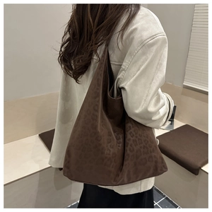 Rear view of a model carrying a large leopard print tote bag for daily commuting