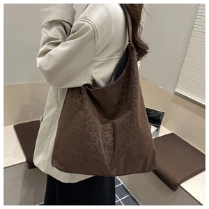 Close-up of a large leopard print tote bag in dark brown with textured suede finish
