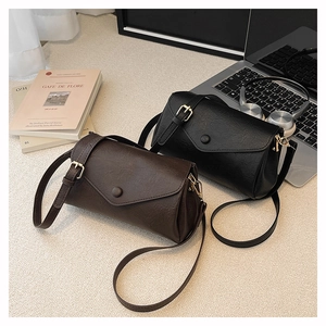 Detail of vintage PU leather crossbody bags in dark brown and black with metal hardware