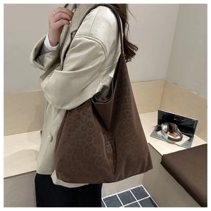 Leopard print tote bag styled with beige leather coat in a modern office interior