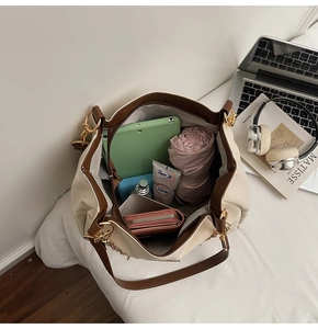 Detail shot showing the spacious interior of a bicolor tote bag with daily essentials