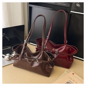 Close-up of vintage leather tote bags in dark brown and red with buckle details