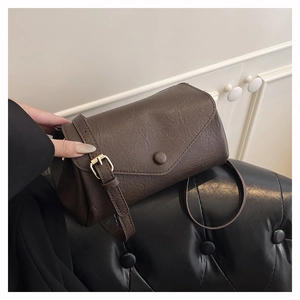 Detail of dark brown vintage faux leather crossbody bag with natural wrinkled texture