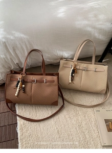 Detail of woven tote bags with leather trim and decorative wooden beads on a soft carpet