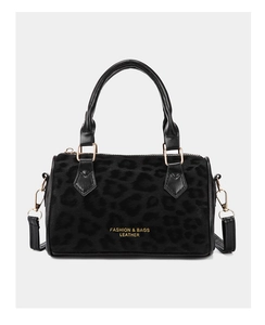 Close-up of black leopard texture and gold hardware on minimalist bucket handbag