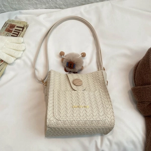 Sac seau tissé beige chic avec boucle en bois et breloque en peluche sur tissu