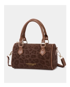 Detail of leopard print bucket bag with gold hardware and leather handles