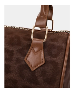 Detail of dark brown leopard print pillow bag with golden metal hardware and faux fur texture