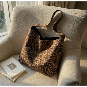 Détail de la texture léopard du sac cabas et forme hobo souple sur fauteuil