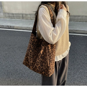 Scatto all'aperto di una borsa tote leopardata sulla spalla di una modella in città