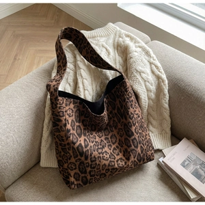 Gros plan de la texture du sac cabas léopard sur un pull en maille beige élégant
