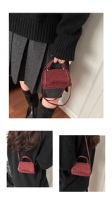 Detail of burgundy mini flap bag with leopard print texture and round top handle