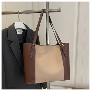 Detail van de kleurblok tote bag met gouden gesp en luxe goudkleurige reliëfopdruk