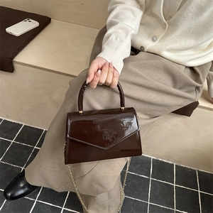 Borsa a mano in pelle verniciata marrone scuro con patta a V e catena dorata