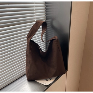 Gros plan d'un sac cabas en daim marron avec une texture mate et un design vintage