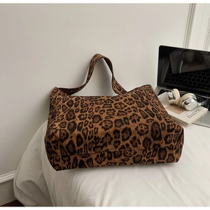Gros plan d'un sac cabas léopard avec un ordinateur et un casque sur un bureau