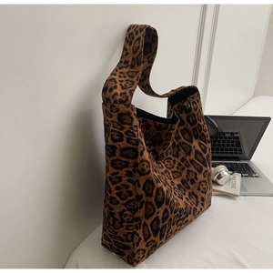 Gros plan du sac fourre-tout léopard avec large bandoulière à côté d'un ordinateur