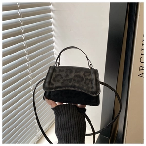 Dettaglio mini borsa in finta pelle scamosciata nera con trama leopardata e manico