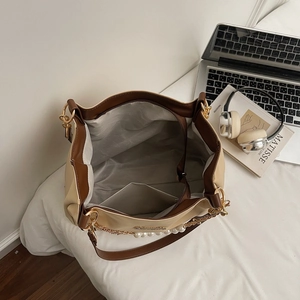 Minimalist beige and brown tote bag with pearl chain shown from a top-down view