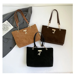 Three suede tote bags in caramel, coffee, and black with golden deer pendants