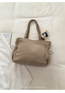 Detail of light brown corduroy tote bag showing textured fabric and drawstring pocket