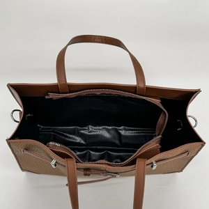 Brown woven leather tote bag with large capacity interior compartment and top handles
