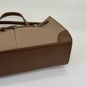 Classic large brown woven tote bag with leather trim and metal buckles for women
