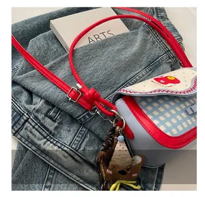 Close-up of red adjustable leather shoulder strap and metal buckle on apple handbag