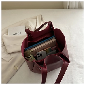 Macro view of burgundy leather tote bag interior showing large capacity and inner pockets