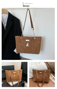 Detail of a brown tote bag featuring golden deer charm and chain link shoulder straps