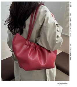 Detail view of red pleated shoulder bag with fashion bags print worn by model