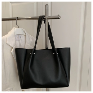 Detail of silver rivets on black matte PU leather tote bag with pleated texture