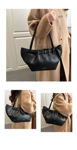 Detail view of black pleated shoulder bag with fashion bags gold logo and smooth matte leather