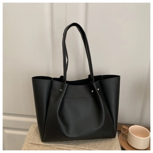 Detail of black PU leather tote bag with silver rivets and litchi texture for commuting